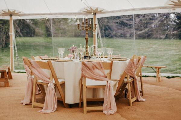 Round tables with white table cloths inside a wedding marquee