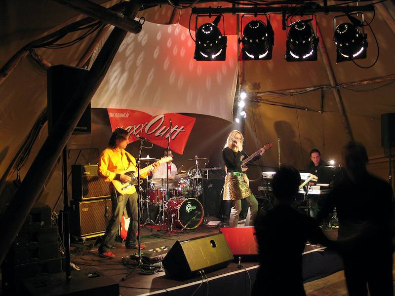 A stage set up inside a Tipi for a corporate event with a band performing and full lighting and sound.
