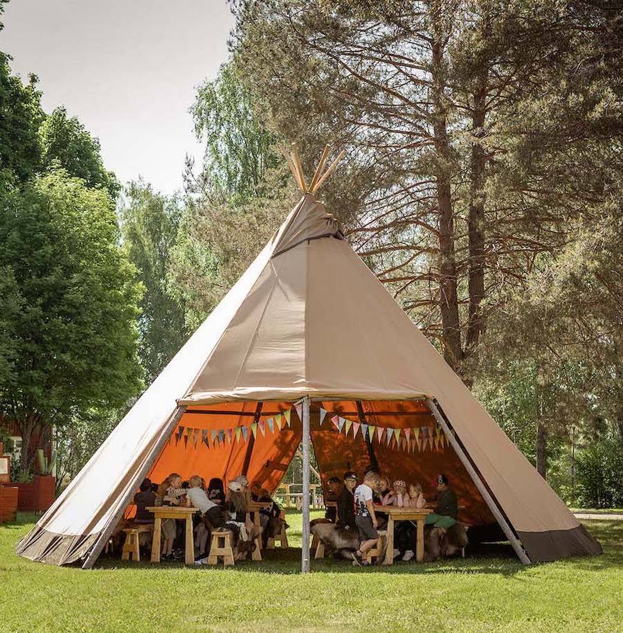 The Medium Tipi or Cirrus 40 is set up in the woods for a children's party in lovely weather.