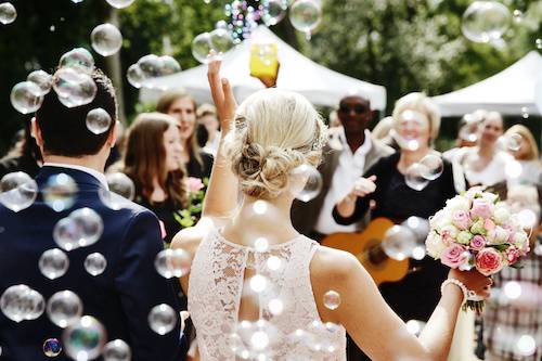 Couple outside best marquee hire surrounded by bubbles