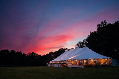 Transform your corporate event into a breathtaking occasion with our Event Tent Rentals. Against a backdrop of a stunning sunset, the spacious and elegant tent illuminates the night sky, providing a sophisticated atmosphere for your guests. Our professional team at Origami Marquees will work with you to create a bespoke and unforgettable experience for your next corporate event.