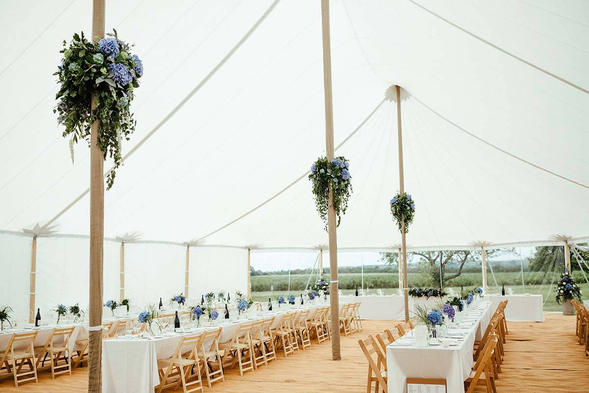 A beautiful Sperry tent interior with follage and tables.